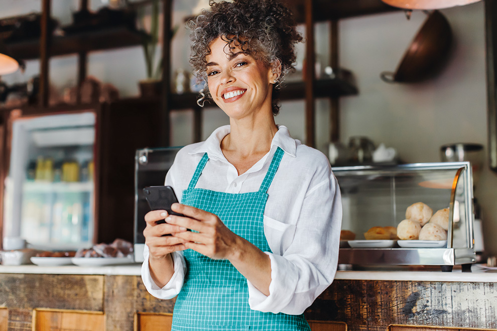 Mulher acessando o app Sicoob para fazer o Crédito para público PJ